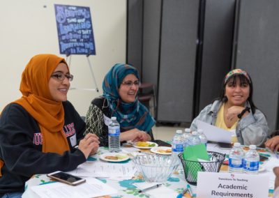 Three people sitting at a table labeled “Academic Requirements”.